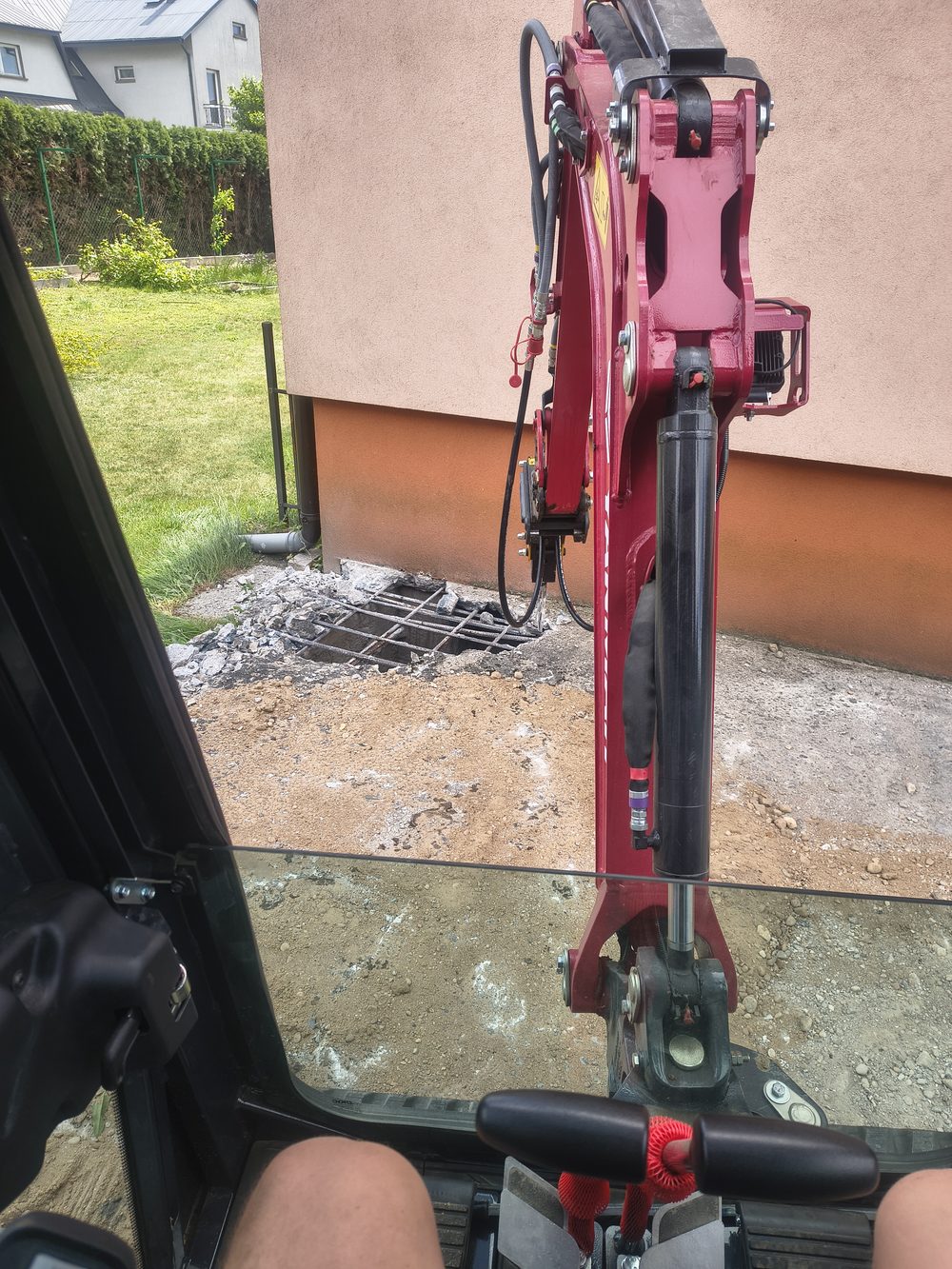 Widok z kabiny minikoparki na wykop pod przyłącze