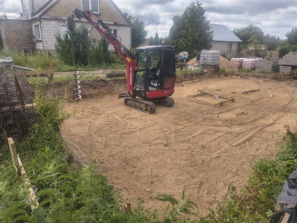 Minikoparka Yanmar SV19 z wiertnicą na wyrównanym placu pod fundamenty